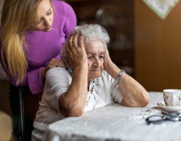 Senior worker consoling her elderly patient